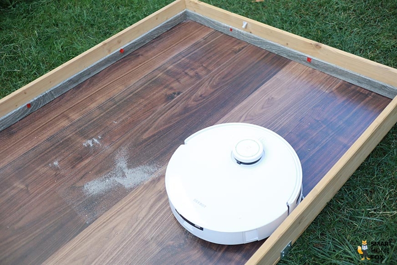 Ecovacs Deebot T10 reinigt im Test Sand auf einem Hartboden.